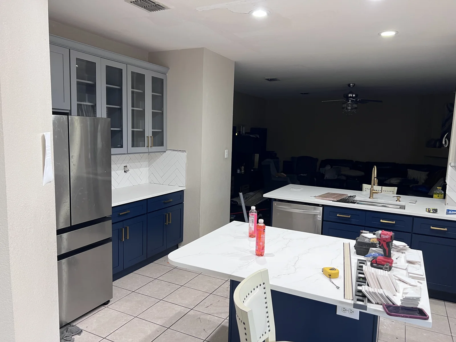Kitchen island, refrigerator and blue-and-white cabinets during finishing work