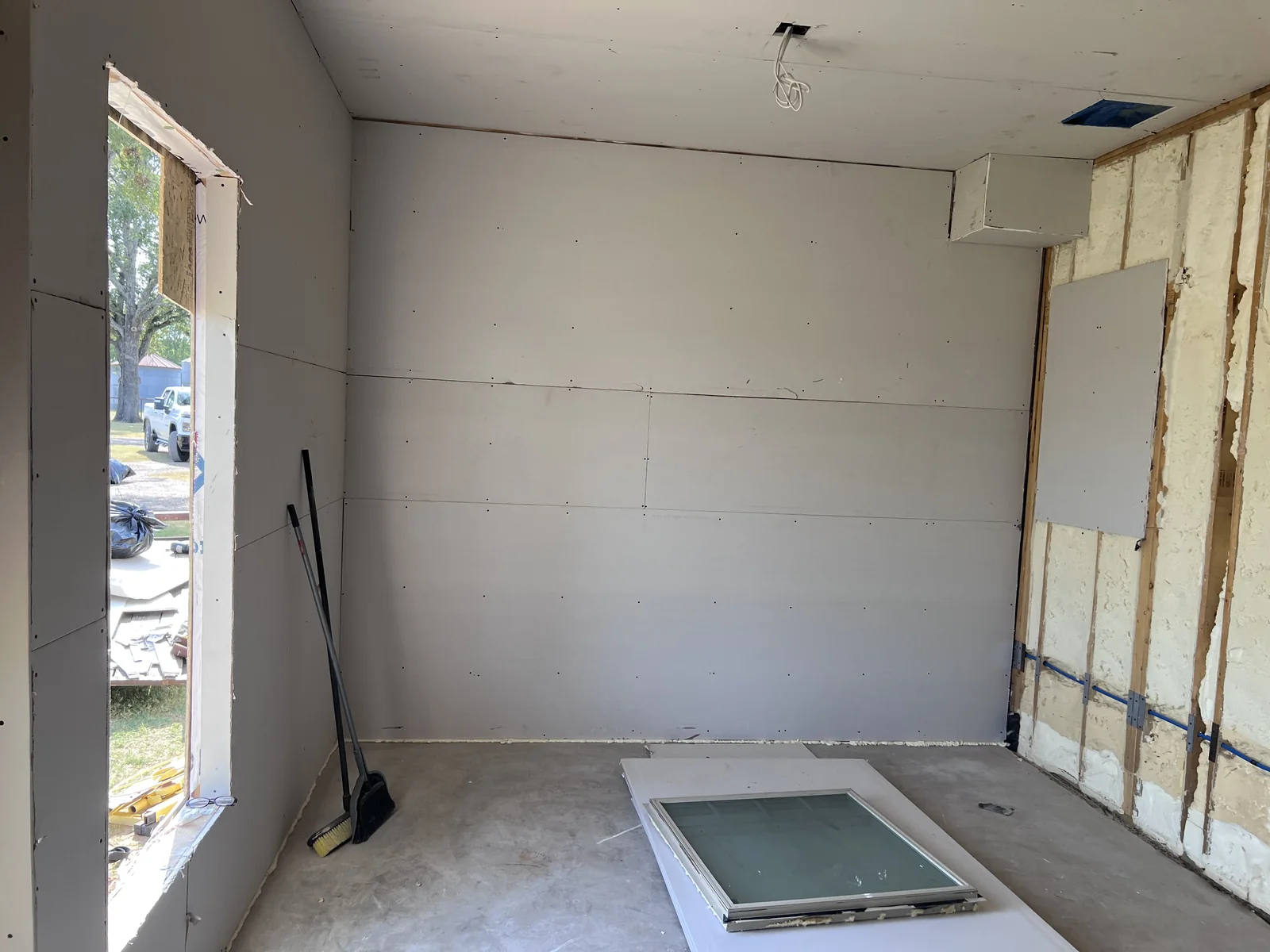 Room under renovation with exposed wall framing and construction materials